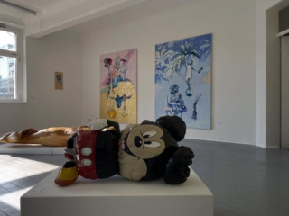 Zur Zeit in der SITTart:
MÄRCHENGOLD 2.0
Anja Kreitz & Anna Mrzyglod
SITTart Raum für Kunst
28.02. – 15.03.2026
Freitags + Samstags 15 – 18 Uhr
Sonntags 14 – 18 Uhr
Die beiden Künstlerinnen haben sich 2022 auf einer gemeinsamen Ausstellung kennengelernt und eine Verwandtschaft in ihren Werken gefunden. Seither stellen sie regelmäßig zusammen aus.
Anna Mrzygłod ist eine polnische Bildhauerin. Sie absolvierte die traditionelle Bildhauerschule in Zakopane und studierte an der Fakultät für Bildhauerei der Schlesischen Universität. Lange Zeit spiegelten ihre Werke die Herkunft wider – die Verbindung zwischen Natur und eigener Erfahrung. Sie spielte mit der illusionistischen Transformation des Materials und suchte den Diskurs über Identität, Erinnerung und Veränderungsprozesse. Durch die Spuren der Zeit entdeckte sie bewusst den farblichen Ausdruck von Emotionen; die Holzoberfläche wurde zur Leinwand mit Farbexperimenten – eine Verschmelzung von Tradition und Moderne. Die Skulpturen von Anna „Märchengold“ Mrzygłod sind auf zahlreichen Ausstellungen im In- und Ausland zu sehen.
Die figurative Malerei von Anja Kreitz beschäftigt sich mit der Epoche des Barocks und dessen Transformation in die heutige Zeit. Sie lässt mit ihrer symbolhaften Sprache eigene Bildfiguren entstehen; Helden und Ikonen aller Art und kunstgeschichtliche Charaktere werden zu neuem malerischen Leben auf den zumeist großformatigen Ölbildern erweckt. Dabei ist die Gratwanderung am Rande zu Lieblichkeit und farblicher Überzeichnung kein Zufall, es ist der gewollte Flirt mit Opulenz und Emotion. Anja Kreitz lebt und arbeitet in Solingen. Die verschiedenen Stationen der künstlerischen Ausbildung haben in der Familie begonnen, führte zur École des Beaux Arts in Paris, zum Bachelor-Abschluss für Malerei mit Auszeichnung an der Hochschule der bildenden Künste in Essen und zur Kunstakademie Düsseldorf in die Klasse Prof. Anzingers.